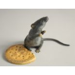 A COLD CAST MODEL OF A RAT standing beside a biscuit. 4.5ins high.