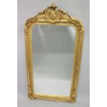 A GILT ROCOCO UPRIGHT MIRROR. 5ft 2ins x 2ft 7ins.