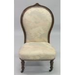 A VICTORIAN MAHOGANY FRAMED NURSING CHAIR with padded back and seat, on porcelain castors.