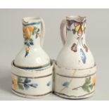 AN 18TH CENTURY TIN GLAZE CRUET with two jugs and a carrying handle. 4.5ins high.