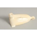 AN INUIT CARVED BONE MODEL OF A SEAL. 3ins long.