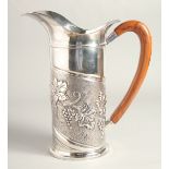 A LARGE FRENCH CESELLATO A MANO 0925 SILVER JUG, repousse with fruiting vines, with wooden