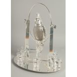A SILVER PLATED COCKTAIL SET as a parrot on a perch, six glasses on an oval base. 15ins high.