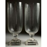 A PAIR OF CUT GLASS STORM LAMPS on square bases. 15ins high.