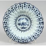 A 19TH CENTURY BLUE AND WHITE RIBBED CHARGER with Chinese design. 13ins diameter.
