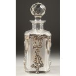 A SQUARE GLASS DECANTER AND STOPPER with silver mounts. 8ins