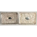 A PAIR OF VICTORIAN STYLE RECTANGULAR DISHES with repousse decoration. 11ins x 7.5ins.