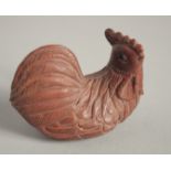 A WOODEN NETSUKE OF A CHICKEN. Signed, 2ins long.