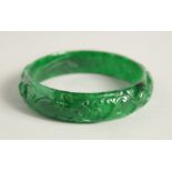 A CARVED JADE BANGLE. 2.25ins diameter.