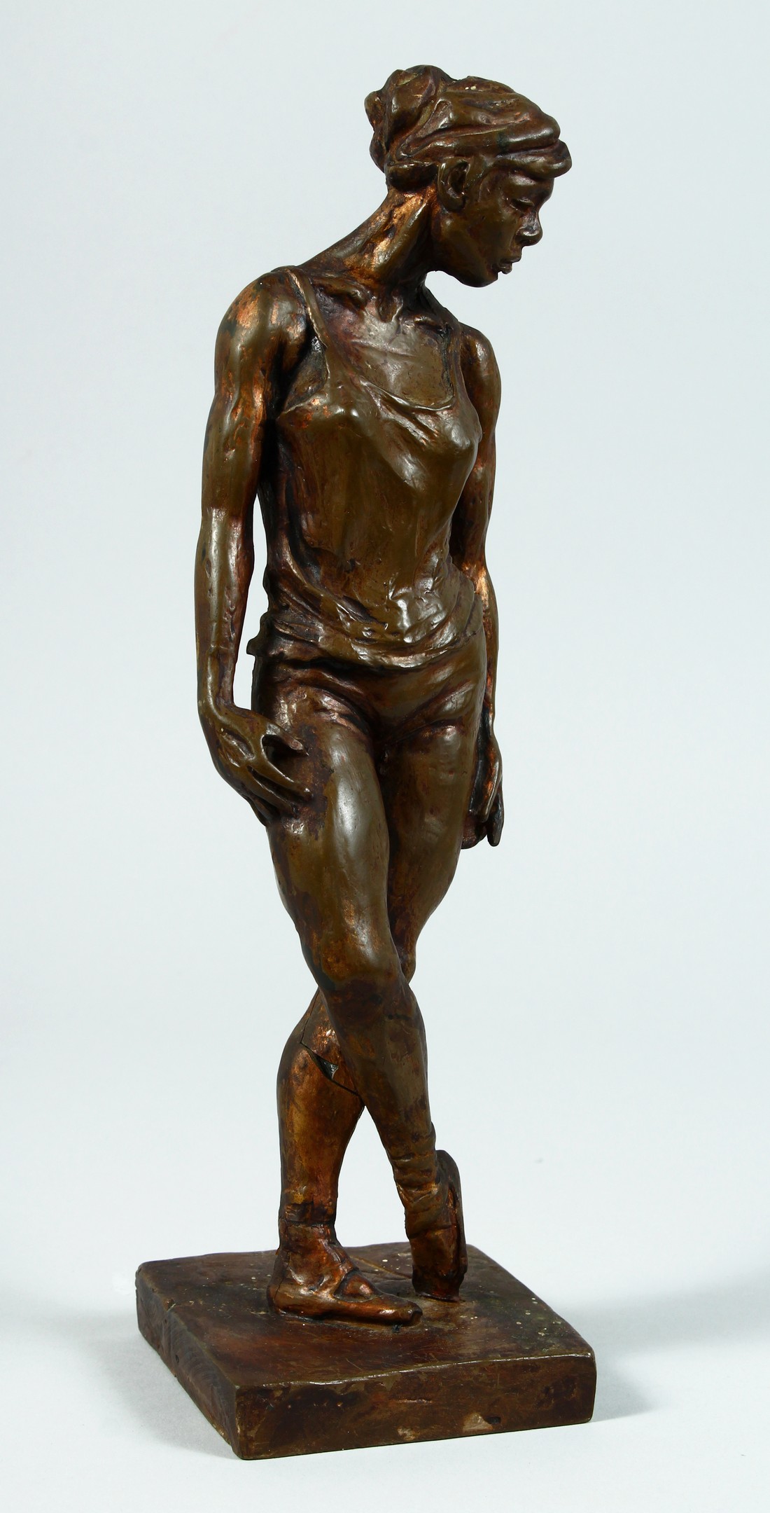 AFTER DEGAS A BRONZED STANDING FEMALE FIGURE on a square base. 13ins high.