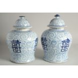 A PAIR OF CHINESE BLUE AND WHITE GINGER JARS AND COVERS. 12ins high.