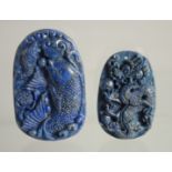 TWO CARVED LAPIS PENDANTS.