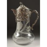 A BULBOUS ENGRAVED GLASS CLARET JUG with plated mounts, lid and handle. 11ins high.