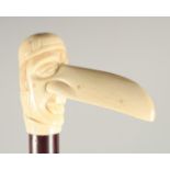 A CARVED BONE HANDLE WALKING STICK, 'LONG NOSE'. 3ft long.