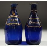 TWO BRISTOL BLUE DECANTERS 'RUM' and 'BRANDY'. 7ins high (one A/F).