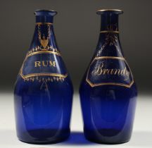 TWO BRISTOL BLUE DECANTERS 'RUM' and 'BRANDY'. 7ins high (one A/F).