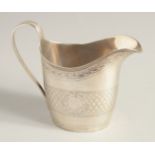 A GEORGE III SILVER CREAM JUG with reeded edge and engraved body. London 1795.