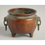 A SMALL CHINESE BRONZE CIRCULAR CENSER with elephant handles. 2.25ins diameter.