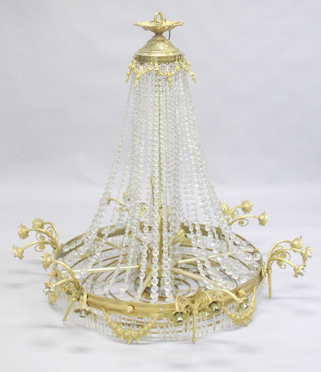 A LARGE ORMOLU AND CRYSTAL CIRCULAR CHANDELIER with four rows of prism drops, six triple pairs of