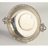 A CIRCULAR SILVER TWO HANDLED FRUIT BOWL with ribbon motif handles. 8.75ins diameter. Chester