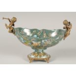 A BRONZE AND PORCELAIN OVAL BOWL with cherubs. 11ins long.
