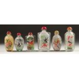 A COLLECTION OF SIX CHINESE SCENT BOTTLES AND STOPPERS painted with fish, pandas, birds, houses, and