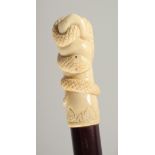 A CARVED BONE HANDLE WALKING STICK, ENTWINED SNAKE. 3ft long.