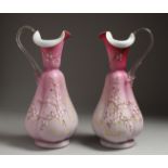 A PAIR OF SATIN GLASS JUGS painted with flowers. 12ins high.