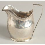 A GEORGE III SILVER CREAM JUG with reeded edge and engraved crest. London 1801 maker A & G BURROWS.