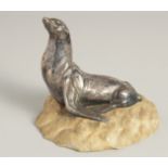 MOREAUX. A MODEL OF A SEA LION on a stone base. Signed. 5ins long.