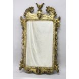 A GOOD GEORGE III DESIGN CARVED WOOD AND GILDED MIRROR with acanthus scrolls, masks and urns. 3ft