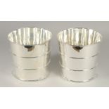 A PAIR OF SILVER PLATED CIRCULAR BARREL COOLERS. 8ins high.