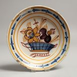 A SMALL TIN GLAZE CIRCULAR PLATE, decorated with a basket of flowers. 6.5ins diameter.