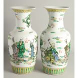 A PAIR OF CHINESE PORCELAIN VASES painted with people. 1ft 5ins high.