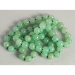 A STRING OF JADE BEADS 34ins long.