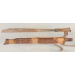 A BONE HANDLED KRIS SWORD in a wooden sheath. 2ft 4ins long.
