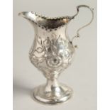 A GEORGE III SILVER CREAM JUG chased with flowers. London 1778. Maker Thomas Holland.