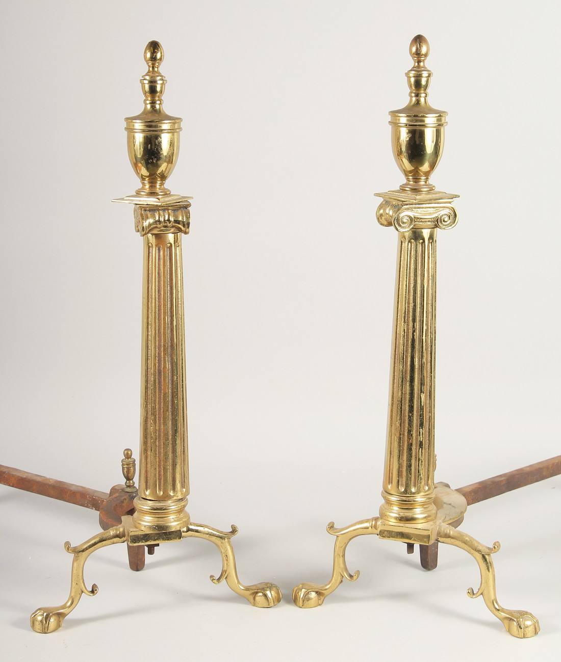 A PAIR OF BRASS COLUMN ANDIRONS. 2ft high.