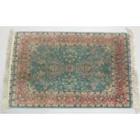 A GOOD SMALL SHIRVAN SILK RUG turquoise ground with floral decoration in a pink ground border.