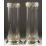 A TALL PAIR OF PLAIN GLASS CIRCULAR VASES with silver bases and rims. 13ins high.