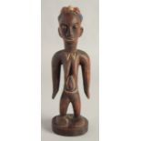 A CARED WOOD TRIBAL FEMALE FIGURE with old pigment. 10.5ins high.
