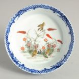 A SMALL BLUE GLAZE SHALLOW BOWL, the interior centre decorated with geese and flora. 12cm diameter.