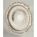 A FRENCH SILVER CIRCULAR WRYTHEN FLUTED FRUIT DISH with cast edge, with shells and acanthus, on four