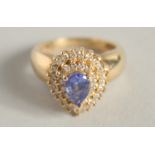 A 14CT GOLD TANZANITE AND DIAMOND TEARDROP RING.