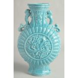 A CHINESE BLUE GLAZE TWIN HANDLED MOON FLASK with a central relief dragon motif. 33cm high.