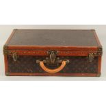 A LOUIS VUITTON SUITCASE. Label faint, also retail label faint, with lift-out tray. Lock no. 065564.