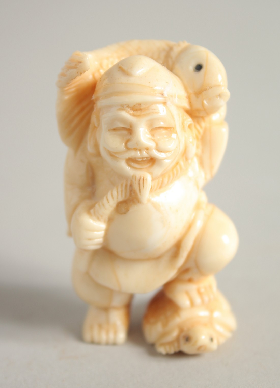 A CARVED BONE FISHERMAN Signed, 2ins.