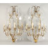A PAIR OF ORNATE BRASS AND CUT GLASS WALL LIGHTS, of two tier form with four light fittings to each,