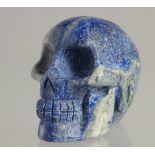 A CARVED LAPIS SKULL 2ins high.