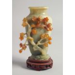 A CHINESE RELIEF CARVED JADE VASE mounted to a hardwood base, the side carved with cherry blossom,